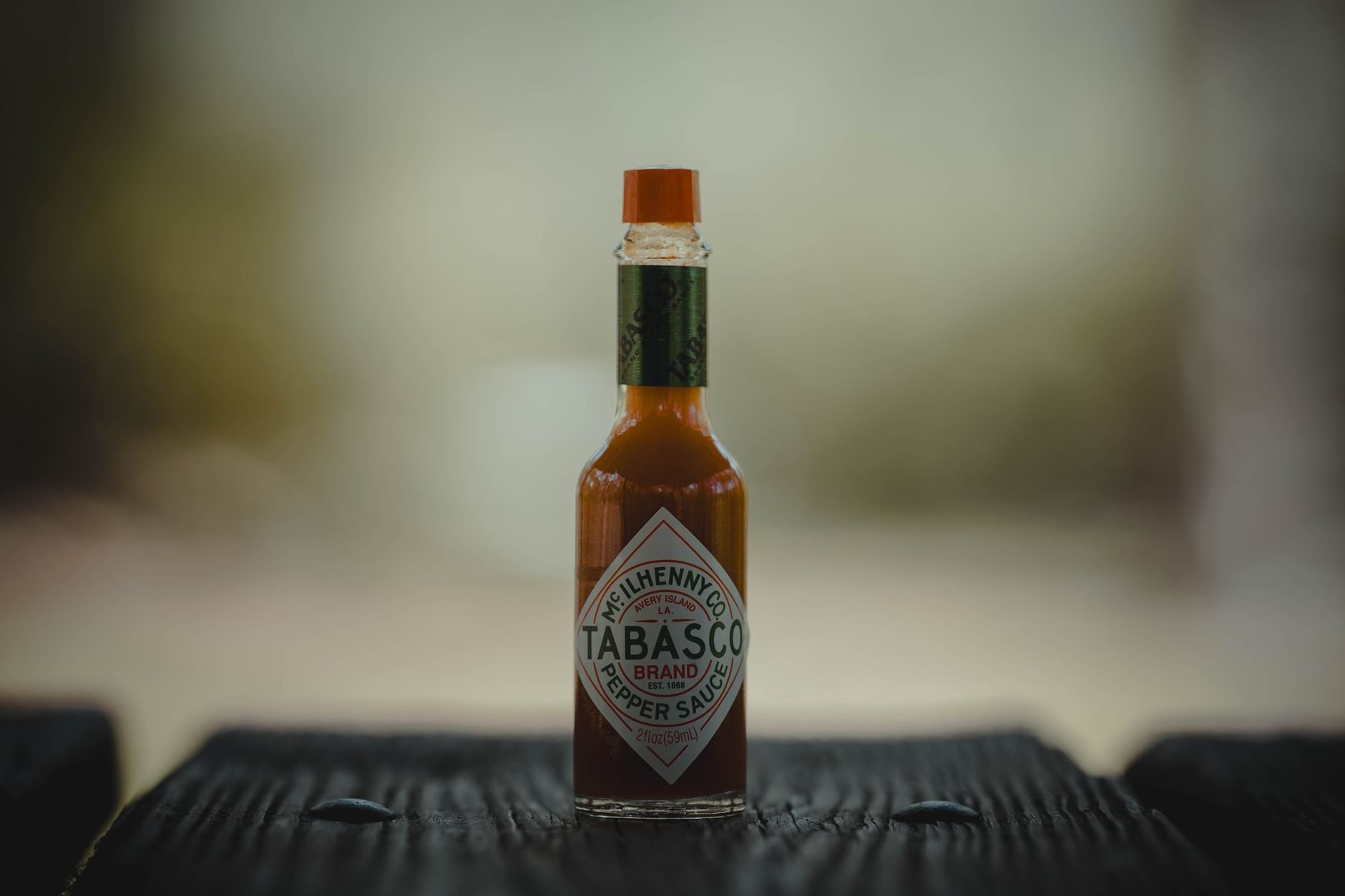 Hot sauce bottle on a wooden surface, highlighting small-batch artisan craftsmanship.